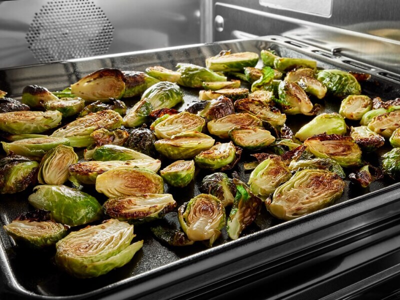 A close up of Brussels sprouts broiling in an oven