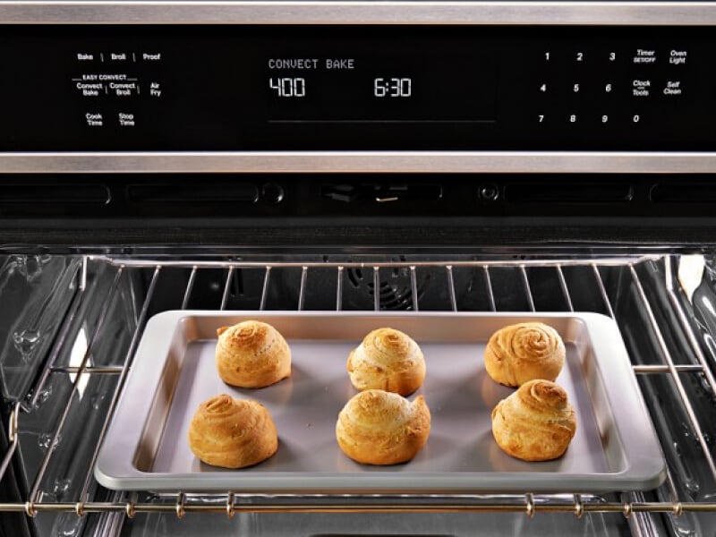 Close up image of bread rolls baking in an oven