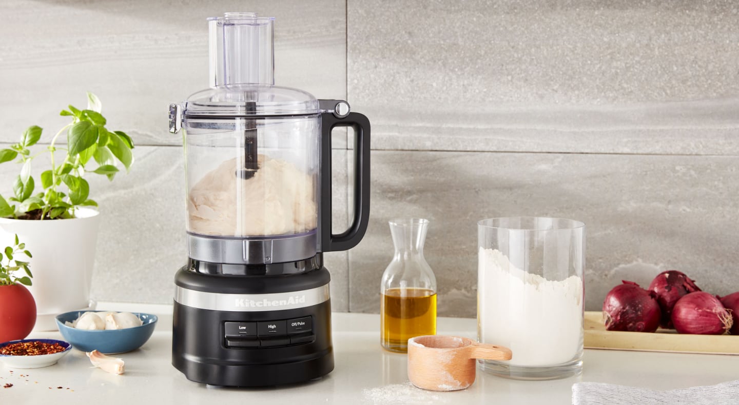 KitchenAid® food processor on counter next to ingredients KitchenAid® food processor on counter next to ingredients