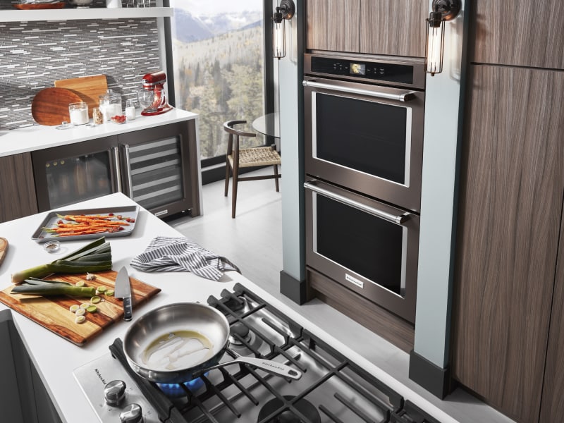Black KitchenAid® double wall oven inside a sleek and modern kitchen Black KitchenAid® double wall oven inside a sleek and modern kitchen