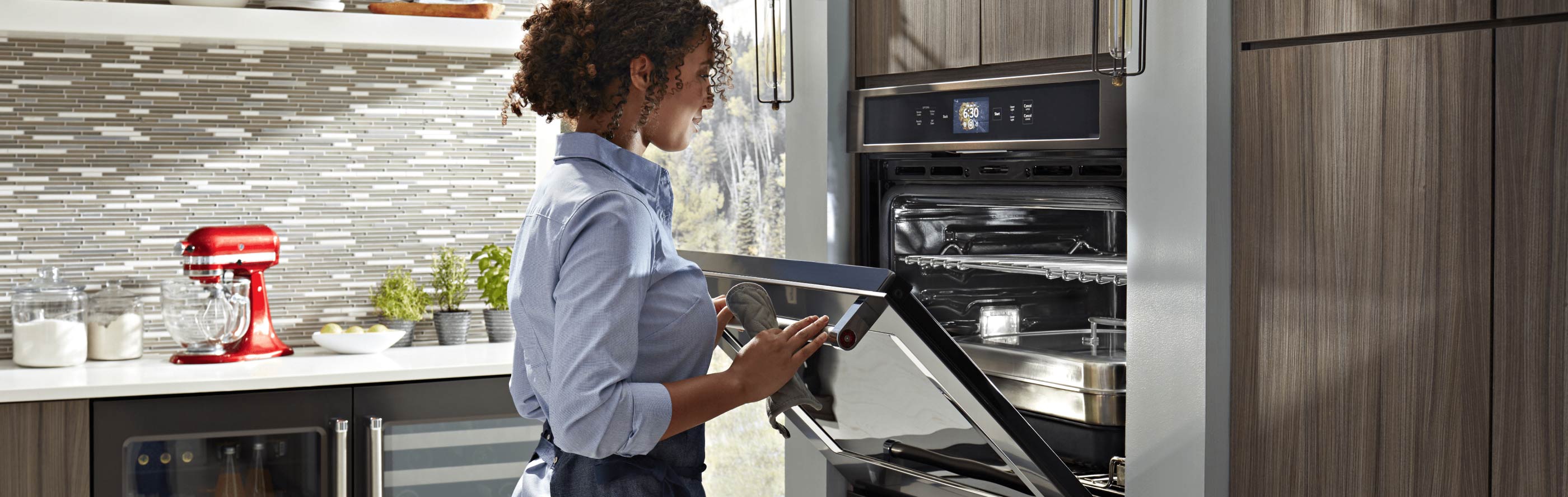 Woman opening an oven door and looking inside