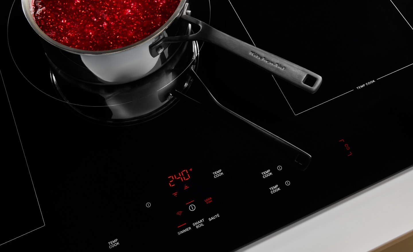 Food simmering in a saucepan on a glass cooktop