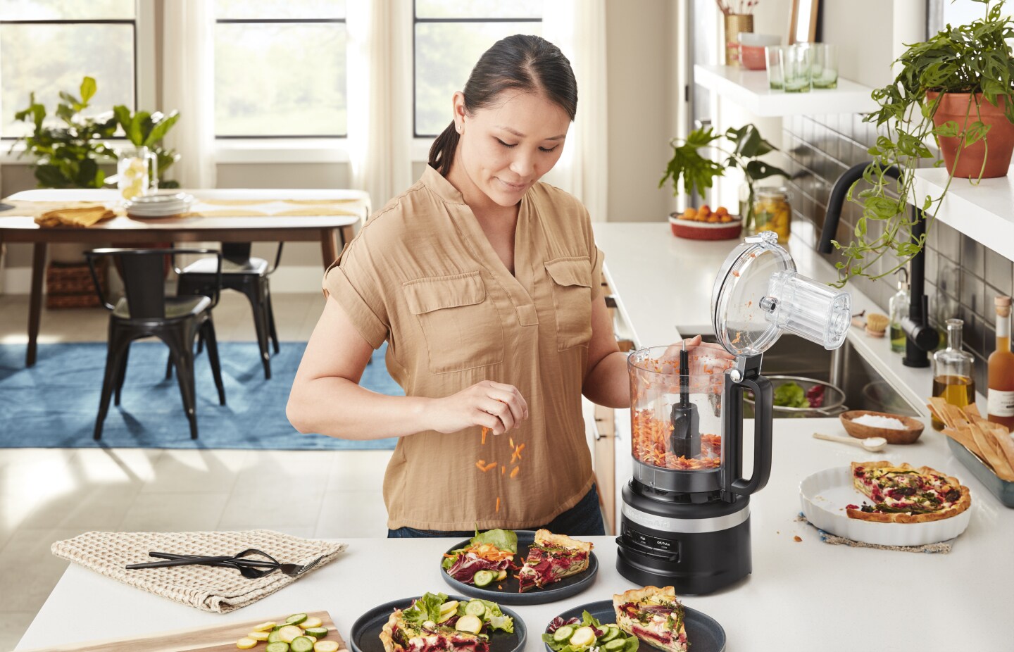 A person sprinkling shredded vegetables onto a pizza. A person sprinkling shredded vegetables onto a pizza.