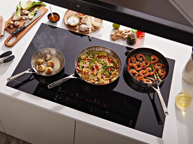 Three dishes cooking on three different burners