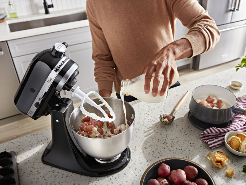 Person pouring milk into a KitchenAid® stand mixer bowl Person pouring milk into a KitchenAid® stand mixer bowl
