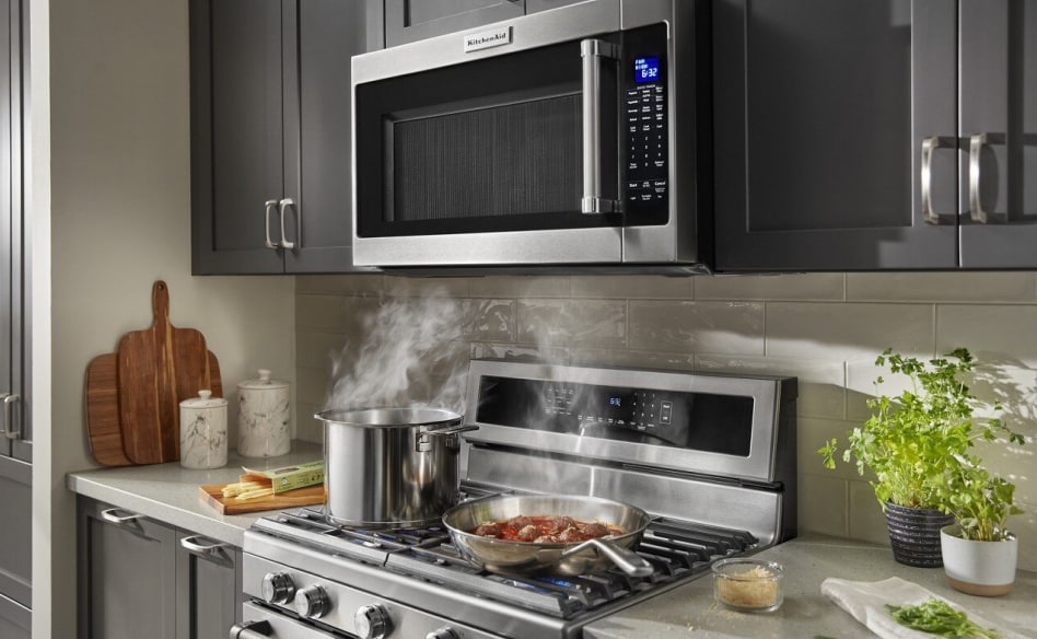 A KitchenAid® microwave installed over a range with food cooking on the different burners A KitchenAid® microwave installed over a range with food cooking on the different burners