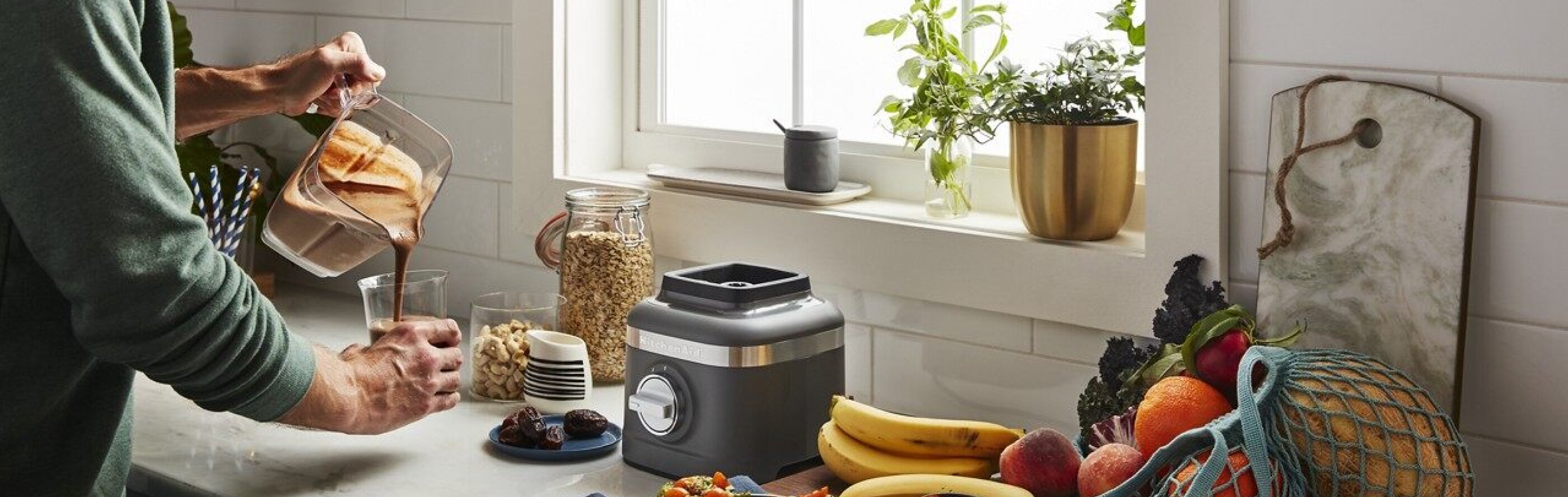 Man pouring drink from blender into glass