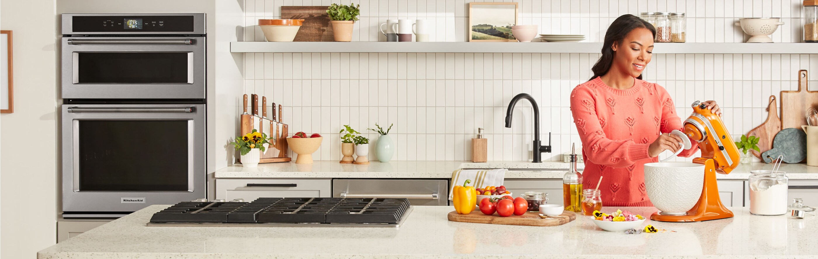 Woman placing dough hook on KitchenAid® stand mixer with white bowl