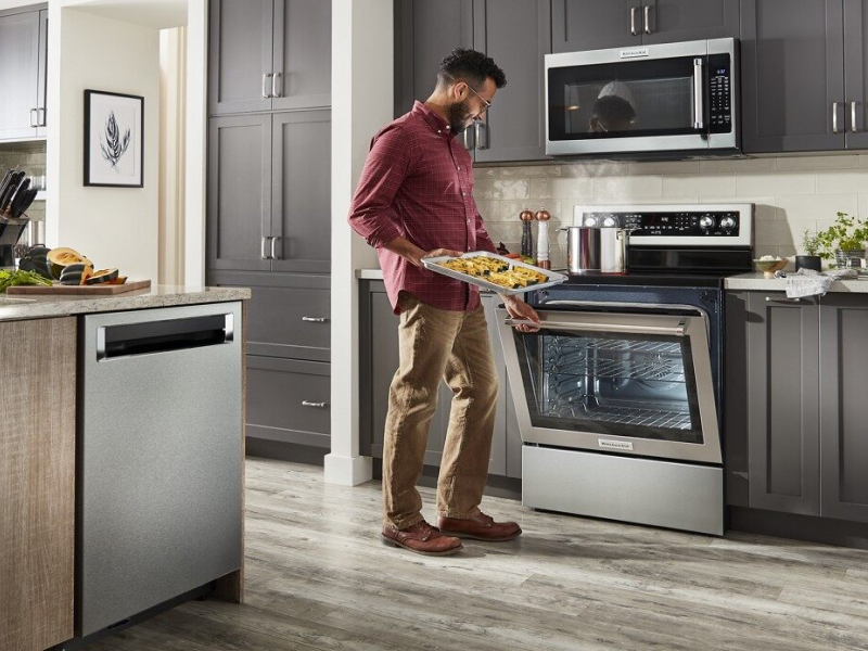 Person baking snacks in KitchenAid® oven Person baking snacks in KitchenAid® oven