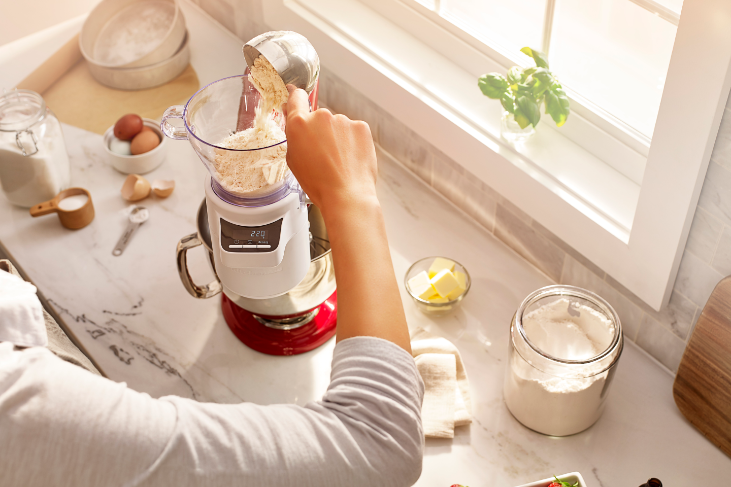 Person pouring flour into KitchenAid® Sifter & Scale Attachment. A person pouring flour into KitchenAid® Sifter & Scale Attachment.
