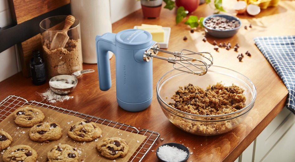 KitchenAid® hand mixer with bowl of cookie dough and wire rack with fresh baked cookies. KitchenAid® hand mixer with bowl of cookie dough and wire rack with fresh baked cookies.