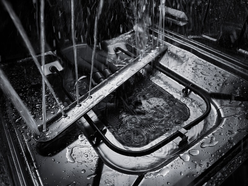 Dishwasher spray arm spraying water