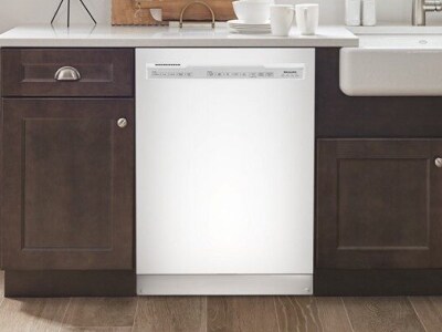 Stainless steel front control dishwasher next to dark cabinets