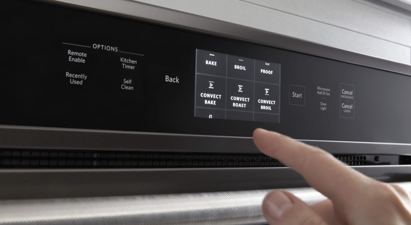 Person selecting settings on oven control panel Person selecting settings on oven control panel
