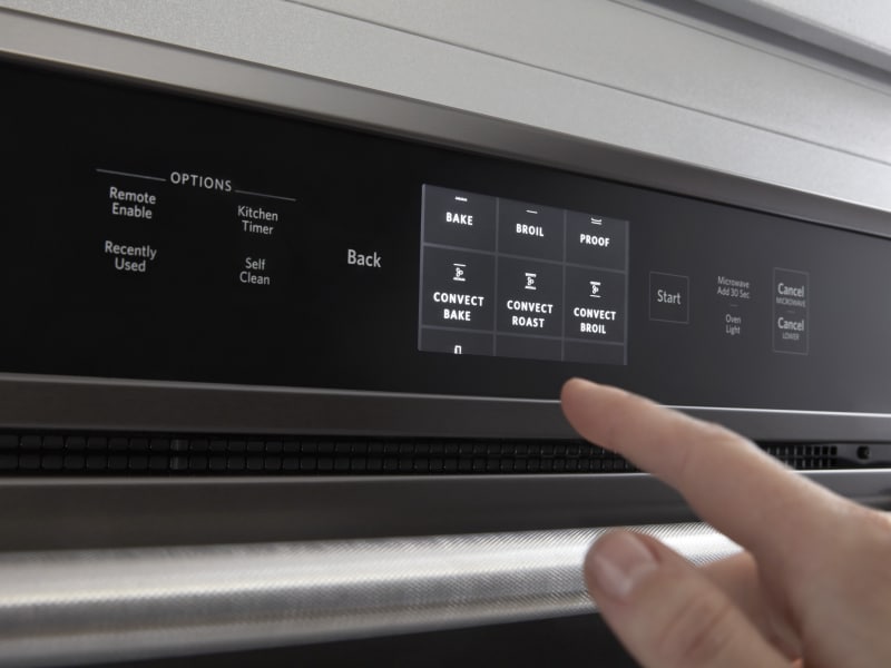 Person selecting settings on oven control panel Person selecting settings on oven control panel