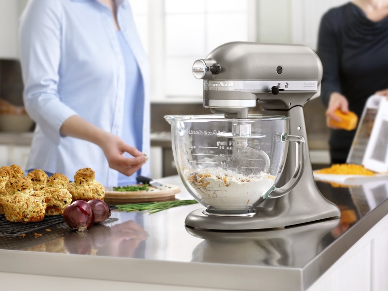 Ingredients mixing in the glass bowl of a silver stand mixer