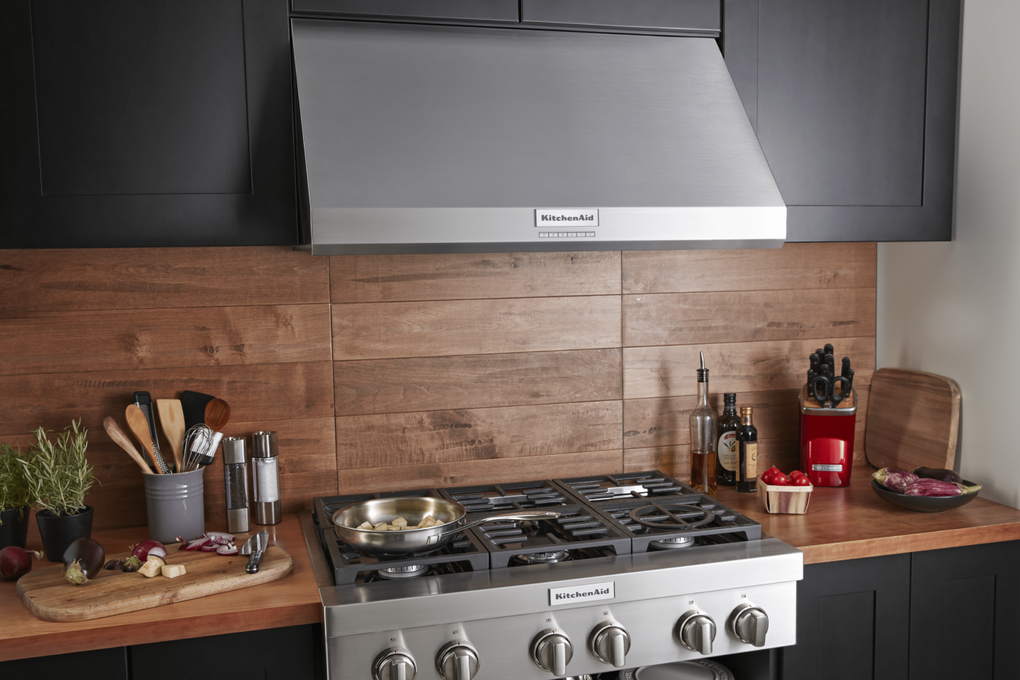 A full kitchen space with cabinets, an oven and a KitchenAid® range hood A full kitchen space with cabinets, an oven and a KitchenAid® range hood