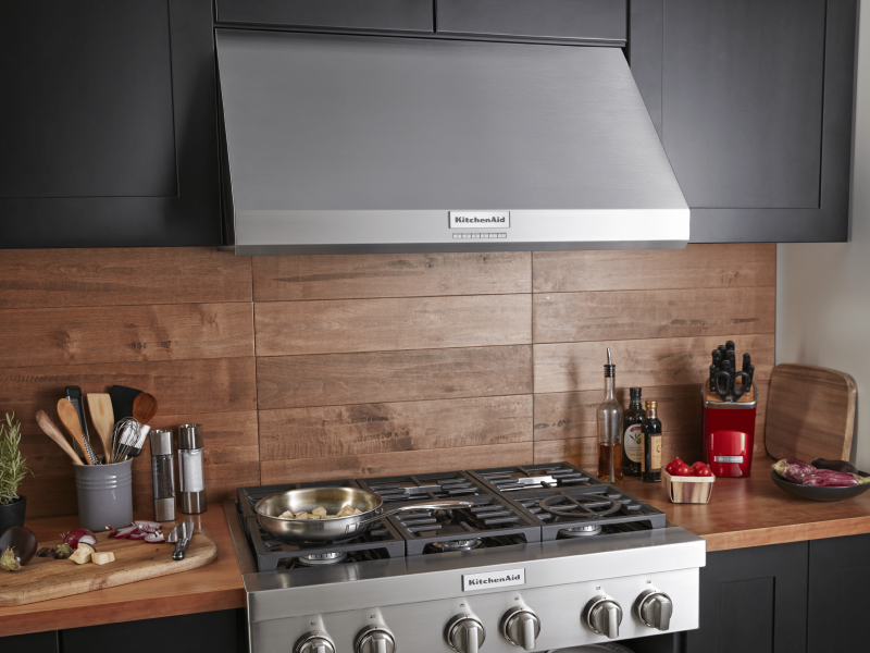 A full kitchen space with cabinets, an oven and a KitchenAid® range hood A full kitchen space with cabinets, an oven and a KitchenAid® range hood