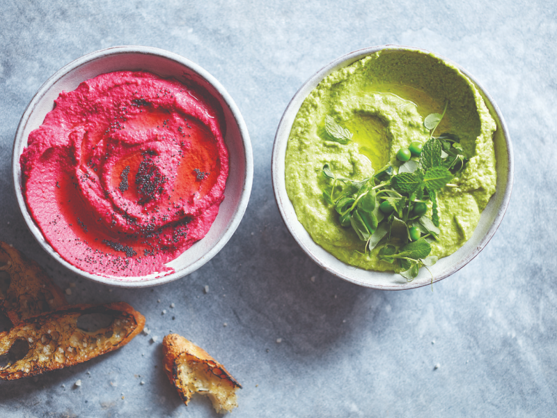Pink and green hummus topped with fresh herbs Pink and green hummus topped with fresh herbs