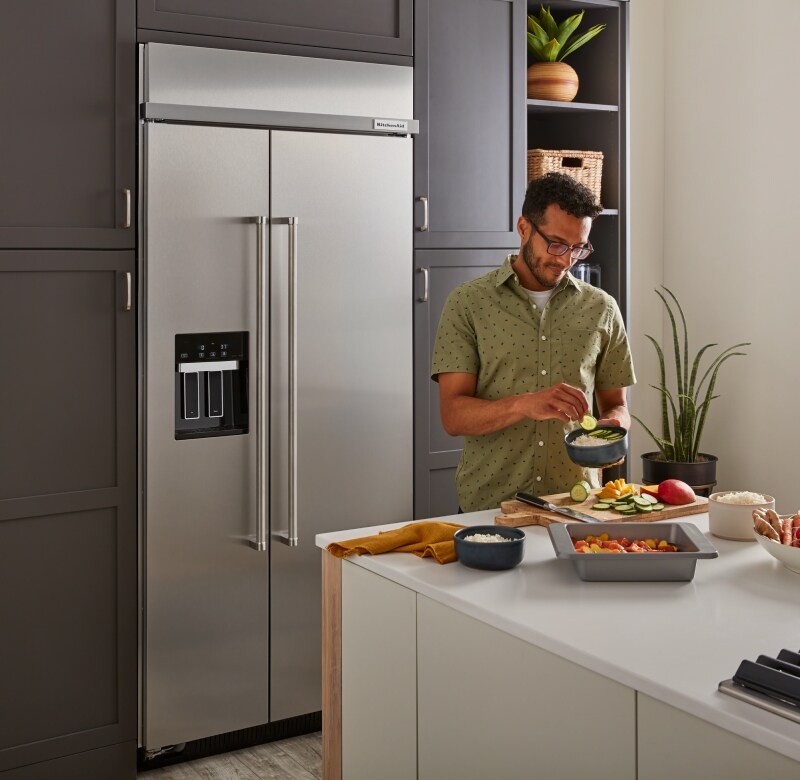 Man preparing rice bowls on kitchen island