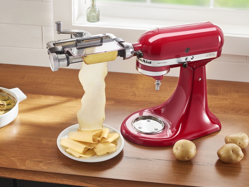 Red KitchenAid® stand mixer with the Vegetables Sheet Cutter Attachment cutting potatoes
