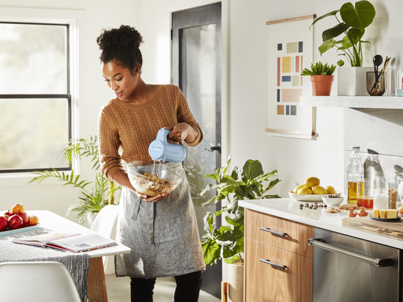 Maker using cordless KitchenAid® hand mixer to blend ingredients in bowl