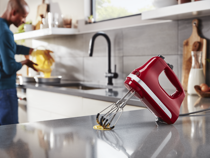 Red KitchenAid® hand blender with flex beater accessory on countertop Red KitchenAid® hand blender with flex beater accessory on countertop