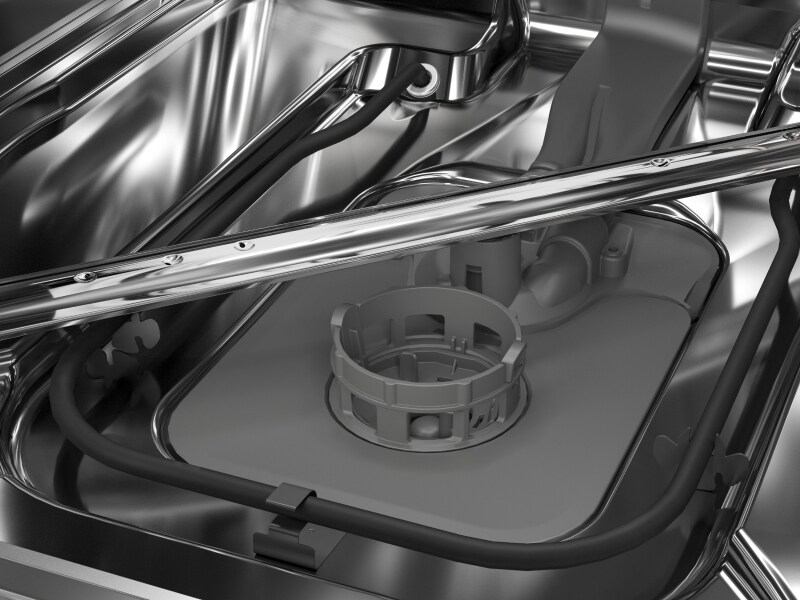 A closeup of a spray arm at the base of a KitchenAid® dishwasher.