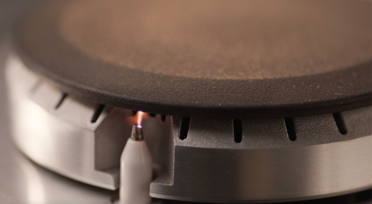 A closeup of an igniter on a gas stovetop