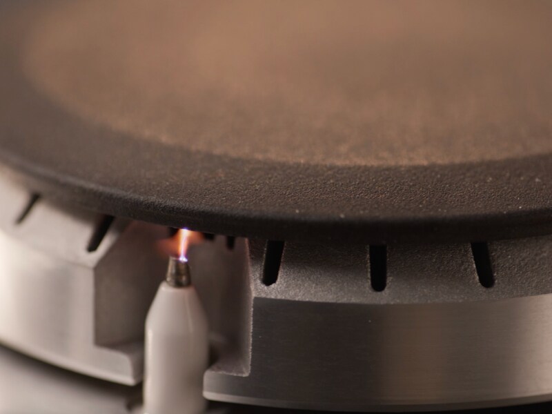 A closeup of an igniter on a gas stovetop
