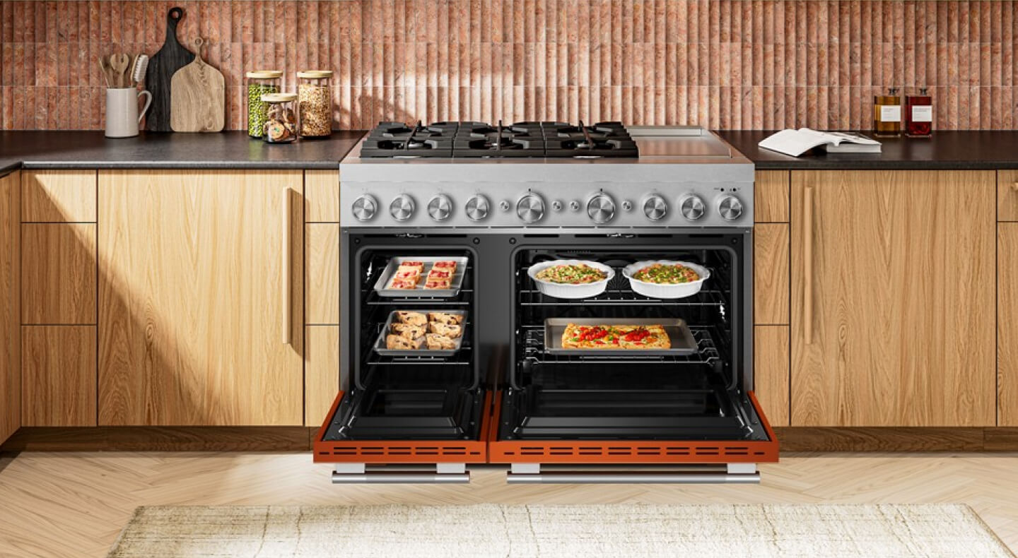 A commercial style double oven gas range with the doors open and food inside
