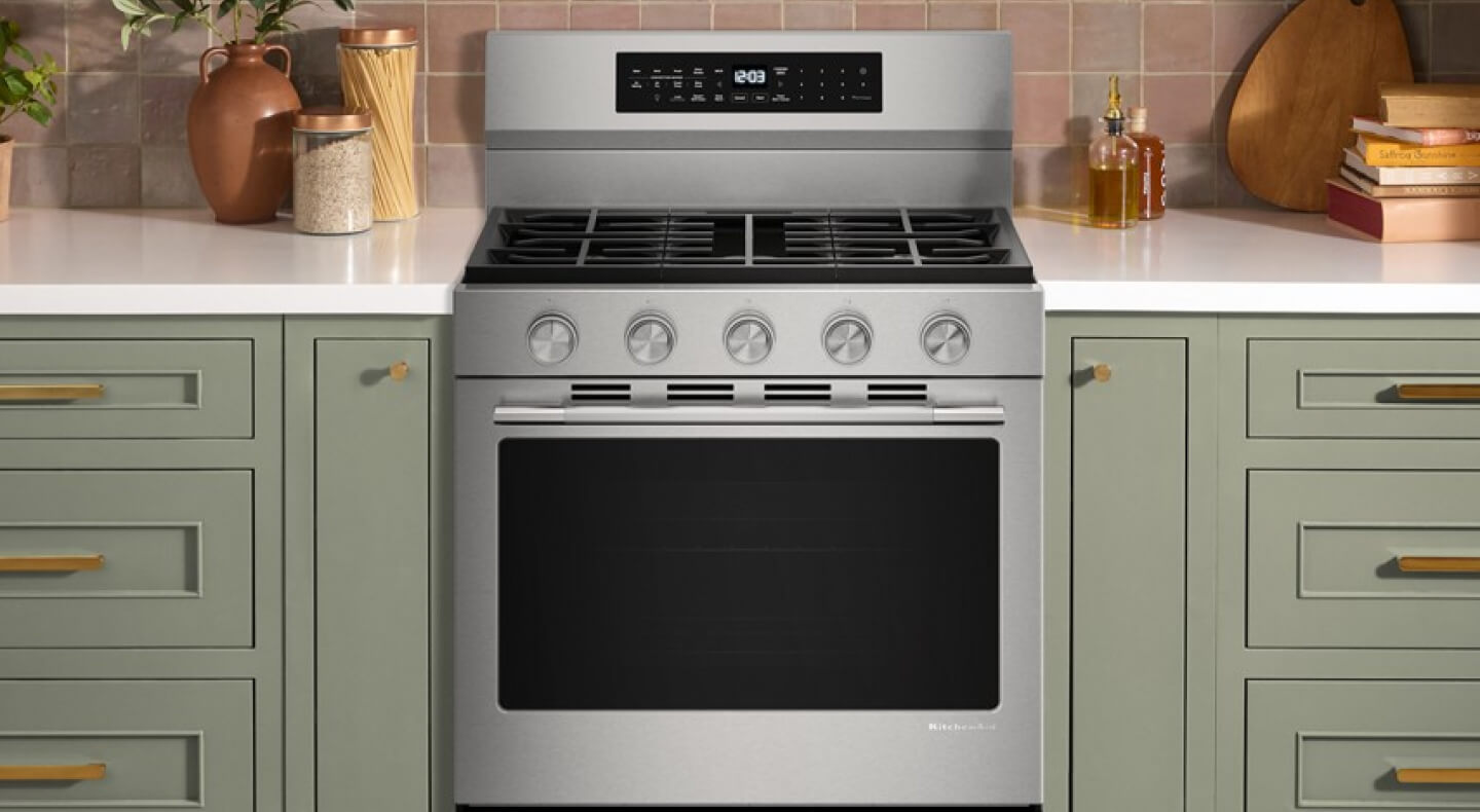 A gas range in a bright kitchen with white countertops