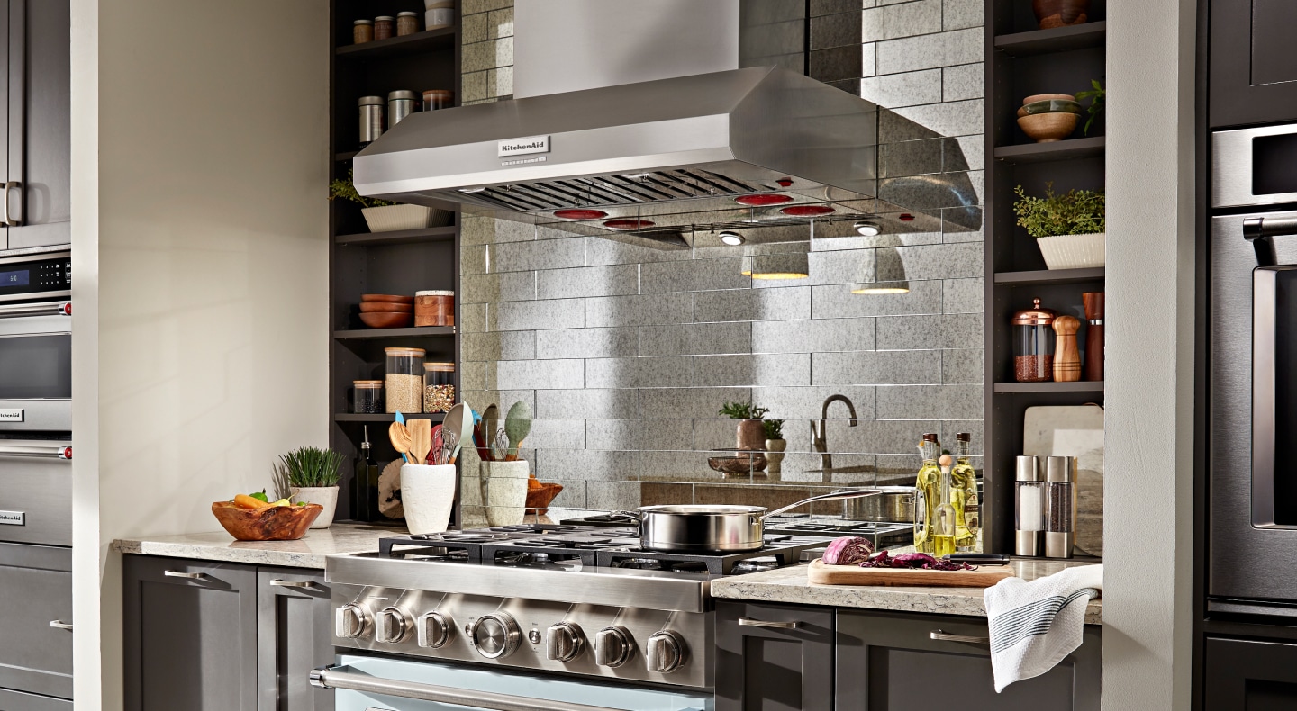 KitchenAid® commercial range hood above gas stovetop with pot on top KitchenAid® commercial range hood above gas stovetop with pot on top
