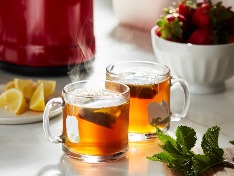 Two glass mugs steeping oolong tea bags