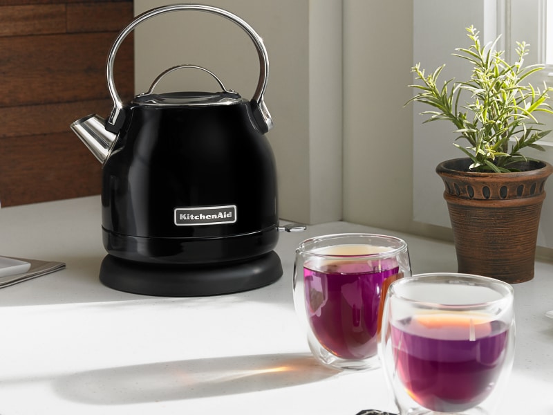 Black KitchenAid® electric kettle next to two glasses of purple tea