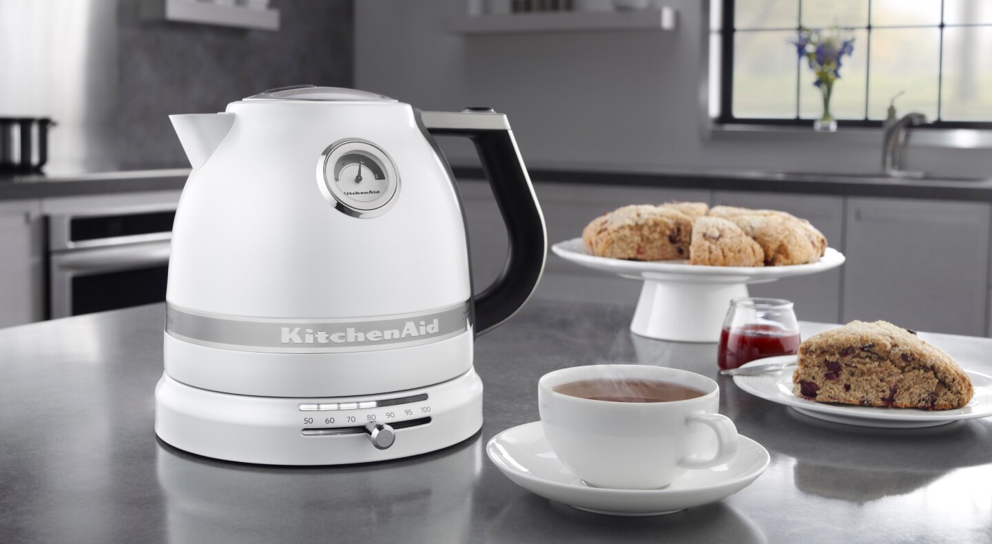 White KitchenAid® electric kettle next to tea and scones