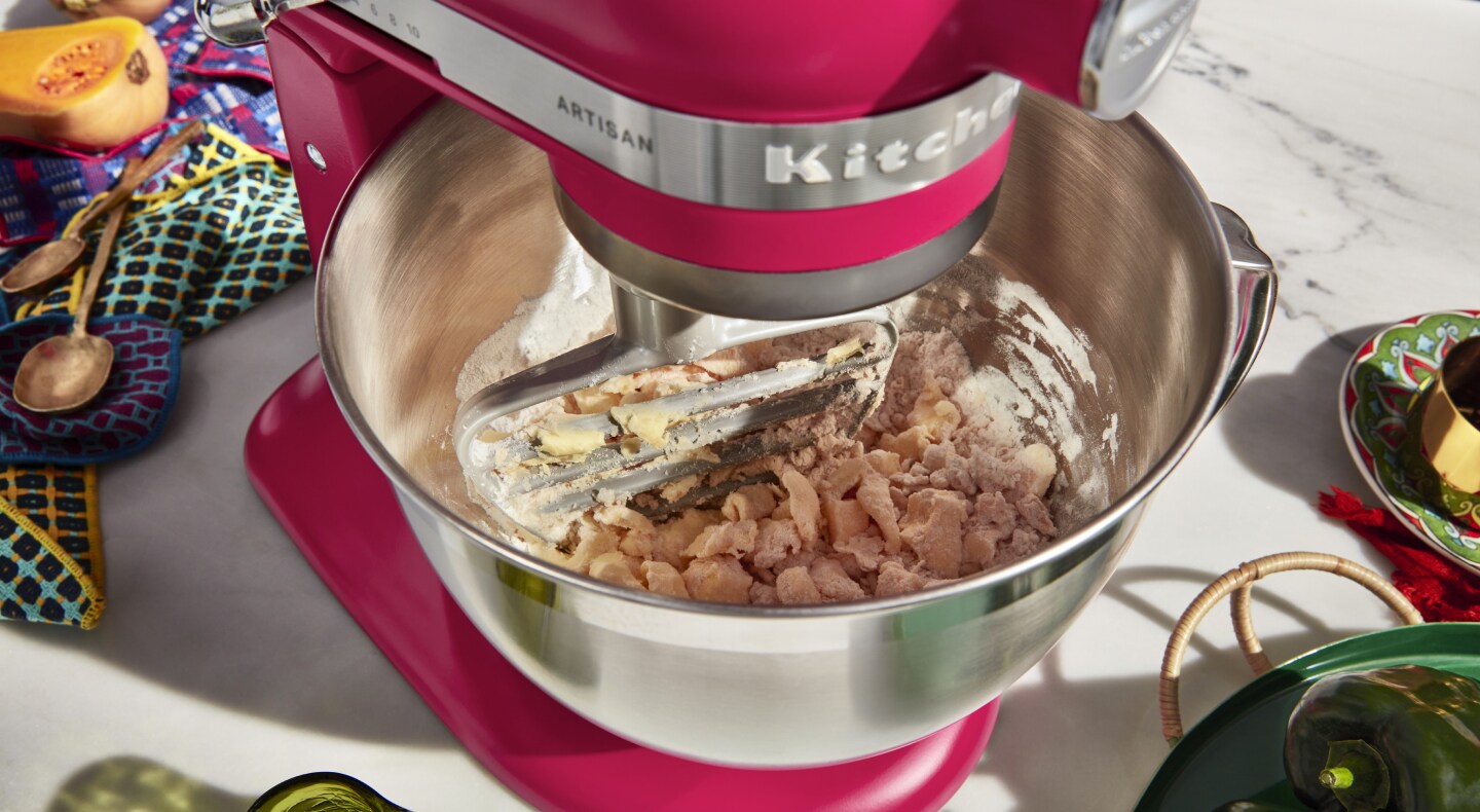 A red KitchenAid® stand mixer used to make dough A red KitchenAid® stand mixer used to make dough