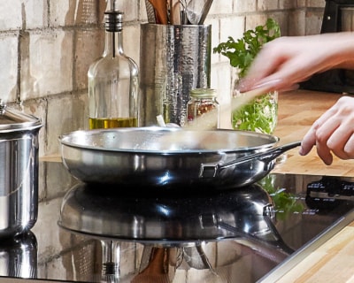 Hand whisking ingredients in a skillet