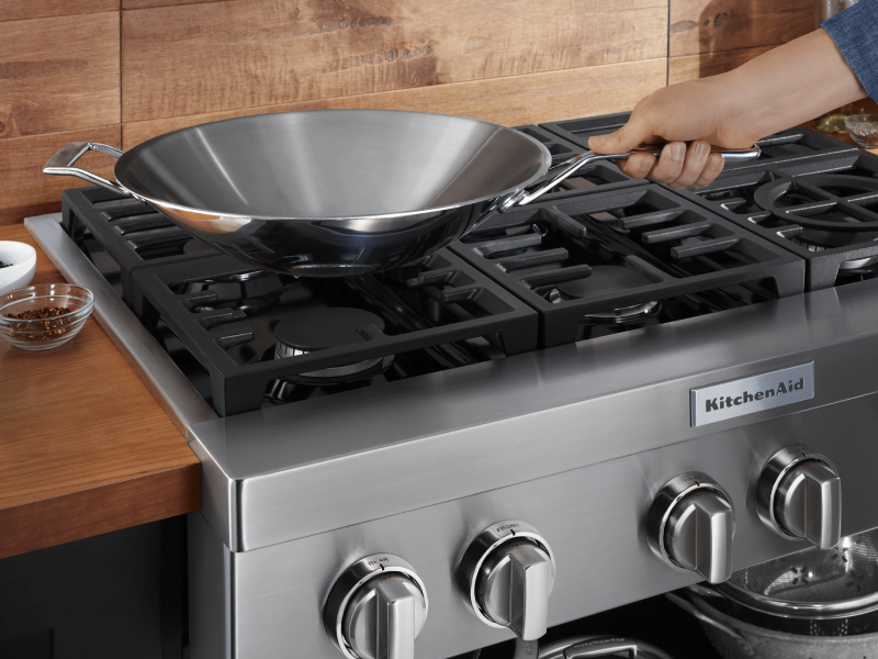 Person holding handle of pan