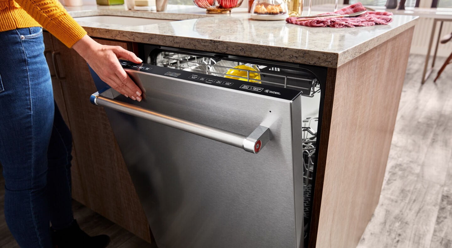 Close-up of hand closing KitchenAid® dishwasher Close-up of hand closing KitchenAid® dishwasher