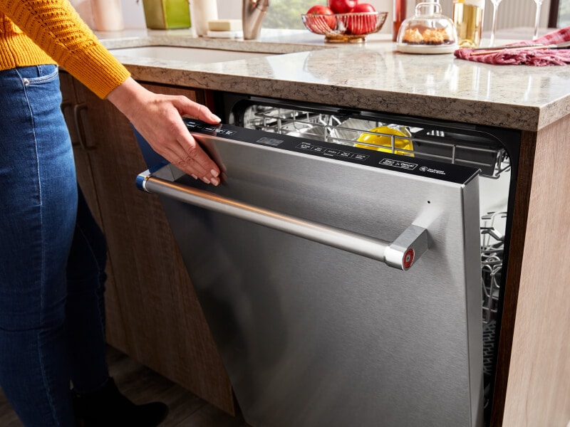 Close-up of hand closing KitchenAid® dishwasher Close-up of hand closing KitchenAid® dishwasher