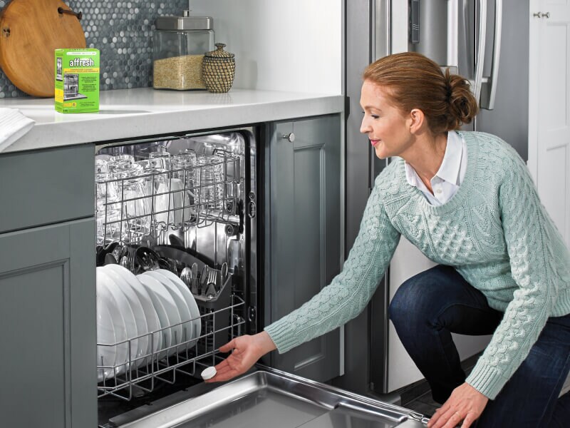 A person using an affresh® dishwasher cleaner tablet to clean their dishwasher A person using an affresh® dishwasher cleaner tablet to clean their dishwasher