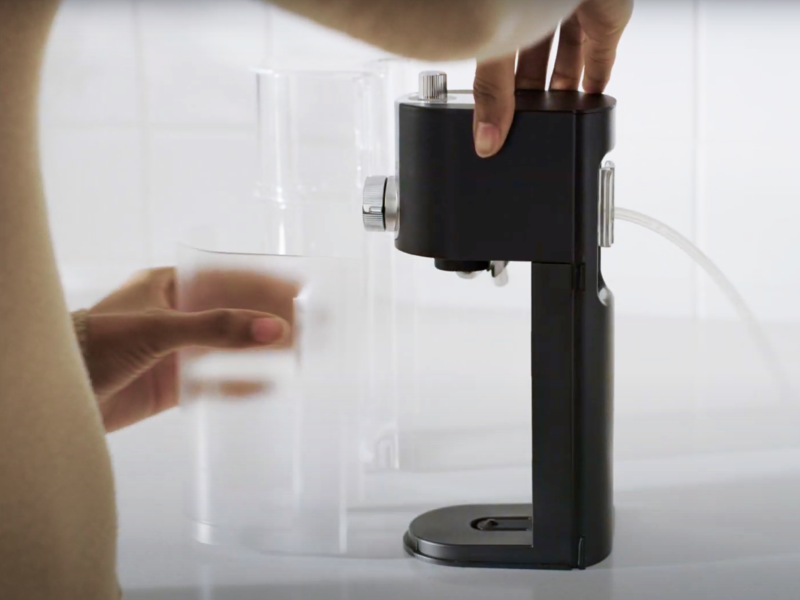 Person removing storage container from milk frother