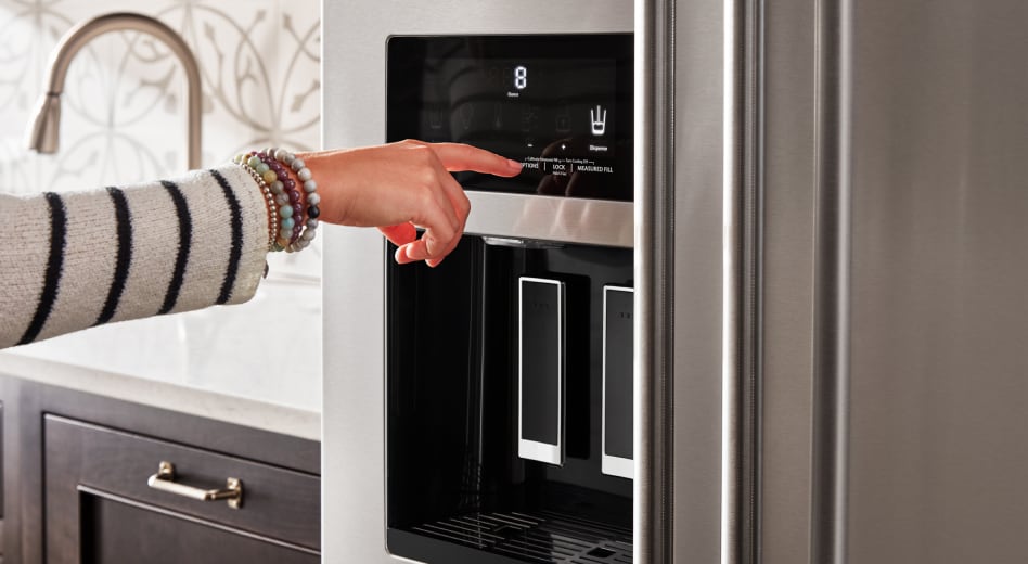 Person pressing the ice dispenser button on a refrigerator Person pressing the ice dispenser button on a refrigerator