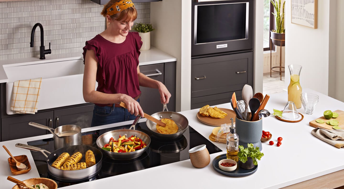 Person cooking multiple dishes on an induction cooktop