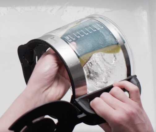 Woman pouring water out of coffee carafe