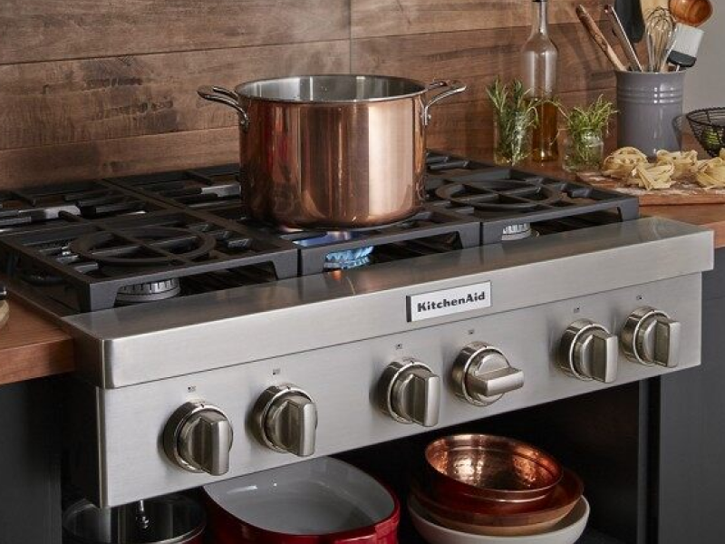 A large pot sitting on an activated KitchenAid® stovetop burner A large pot sitting on an activated KitchenAid® stovetop burner