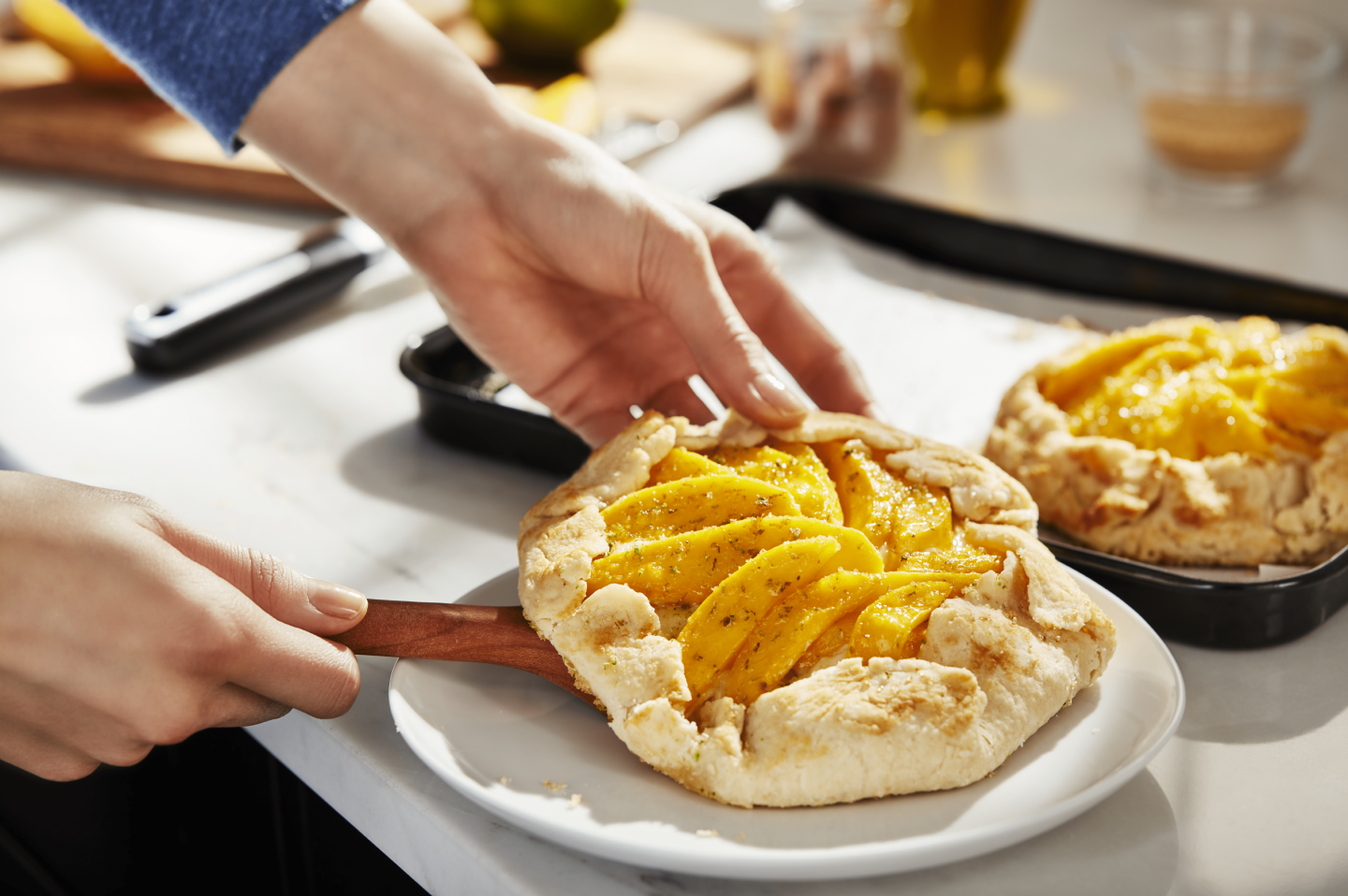 Hands placing homemade apple galette on a plate Hands placing homemade apple galette on a plate