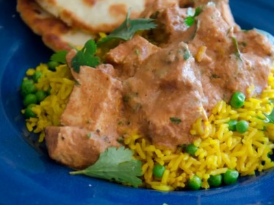 A plate of seasoned rice with beef covered with a sauce.