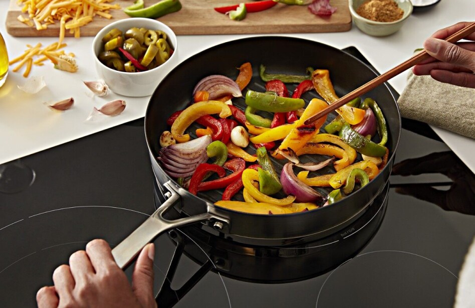 Veggies stir frying on an electric cooktop  Veggies stir frying on an electric cooktop